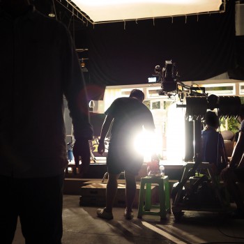 Behind the scenes of video shooting production crew team silhouette and camera equipment in studio.