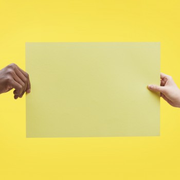 Graphic background image of two hands holding blank paper against pop yellow background, mock up, copy space
